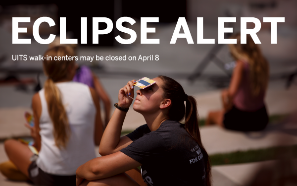 UITS walk-in locations may be closed April 8. Image shows a person looking through eclipse filter.