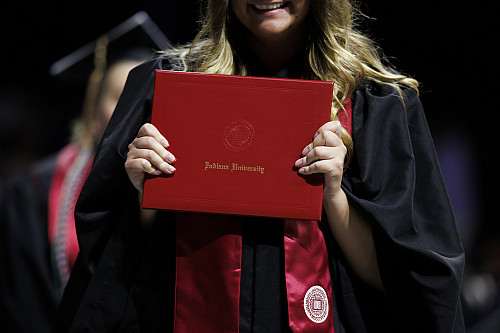 A graduate celebrates with her diploma cover during the IU South Bend Commencement in South Bend 
