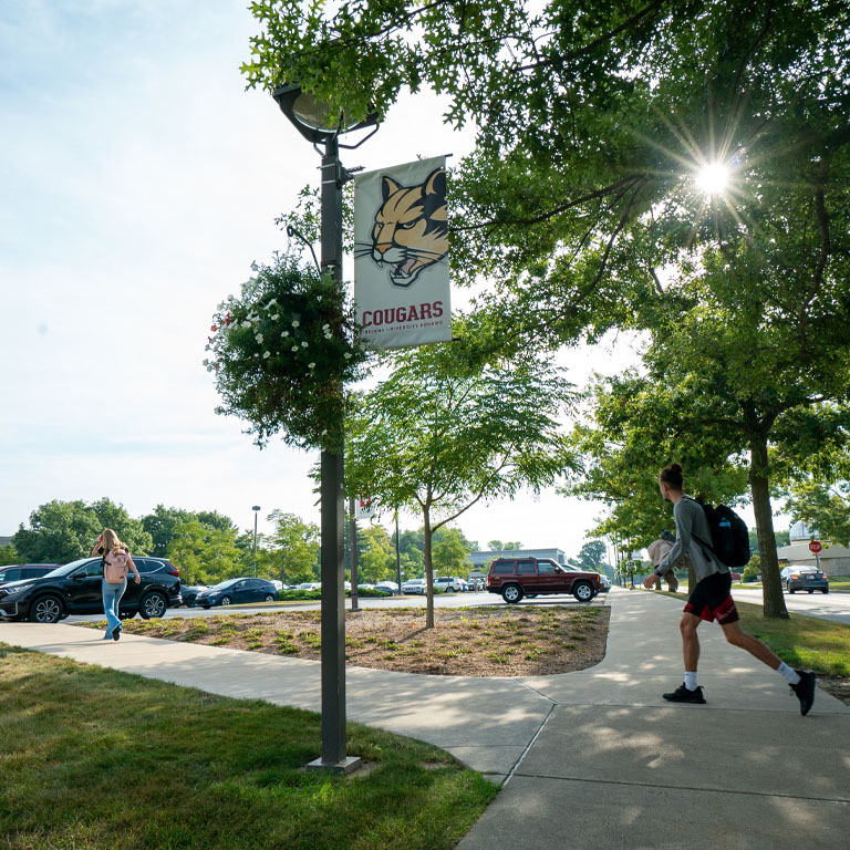 Two students walk on a sunny campus