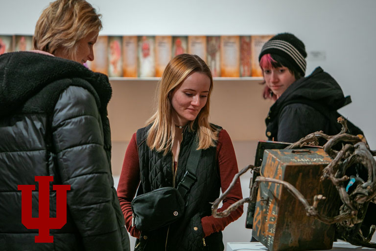 three people look at artwork