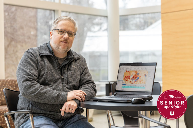 A man sits with a laptop