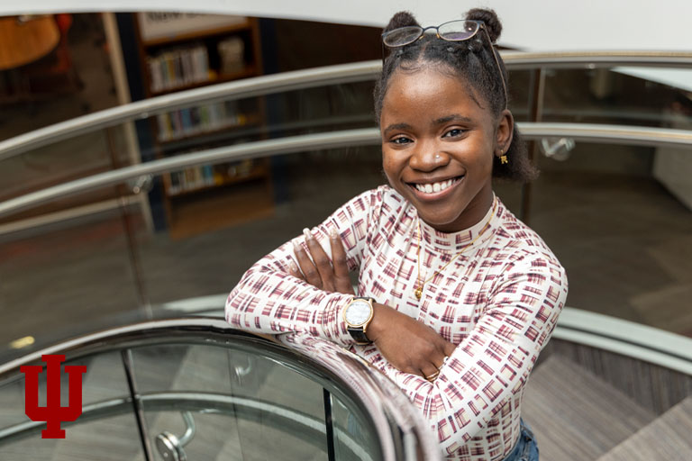 A woman stands on a spiral staircase