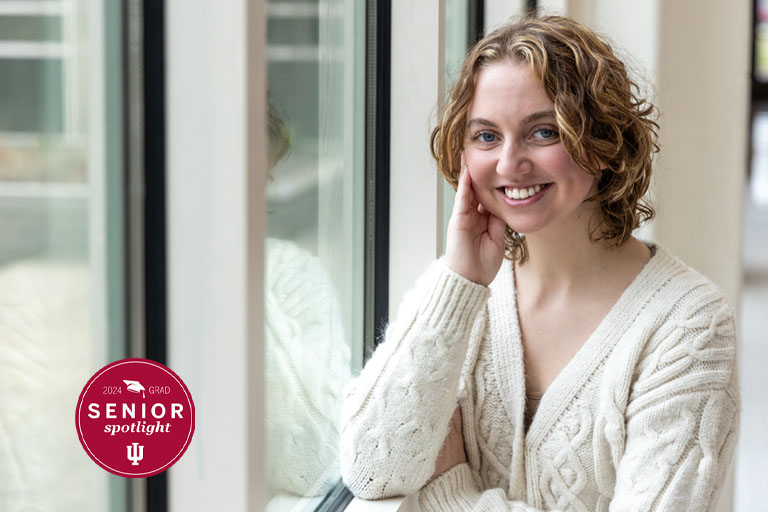 A woman poses by a window