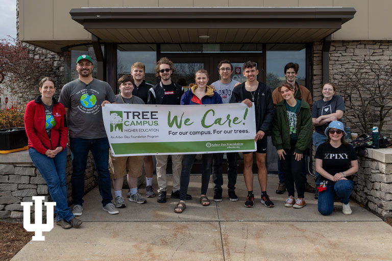 A group of people stand with a sign