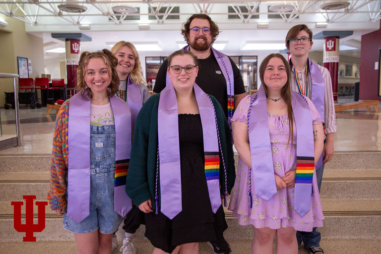 A group picture of people wearing lavender stoles with rainbows