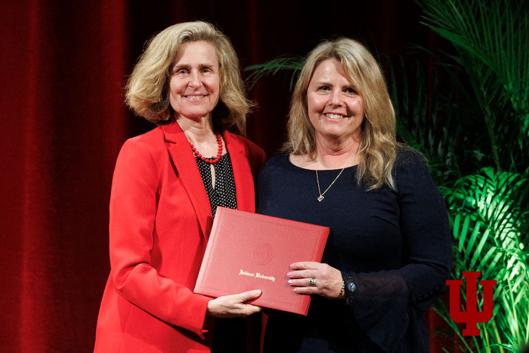 Two women pose with an award certificate
