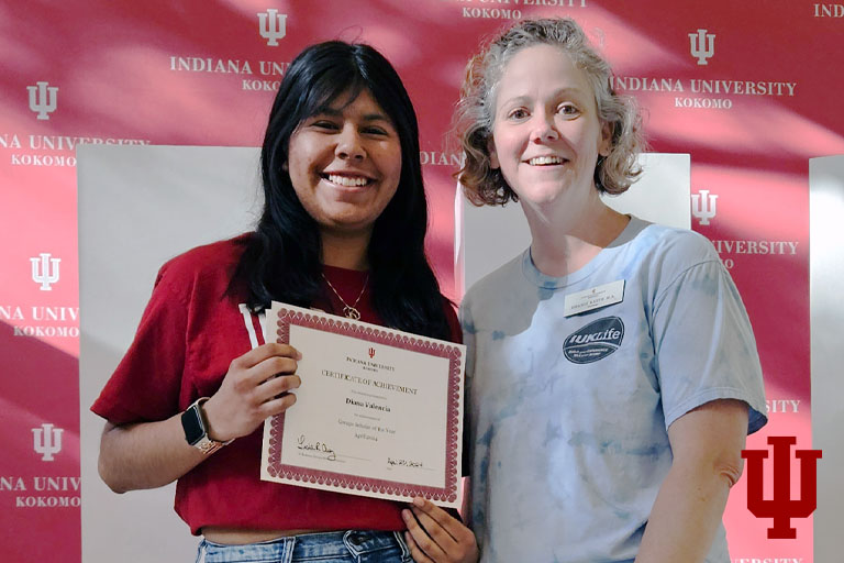 Two women pose with an award