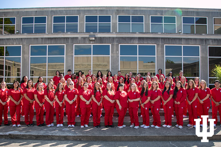 A group photo of people wearing red scrubs
