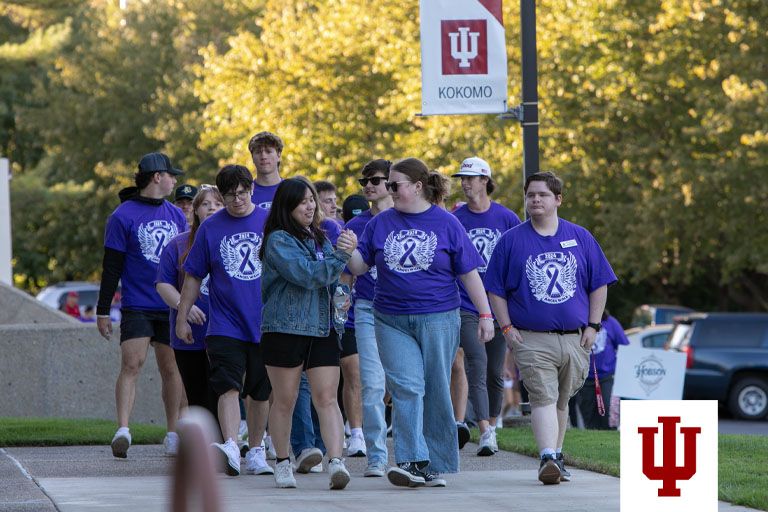 A group of people walk in purple T-shirts