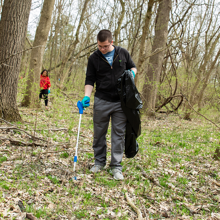 A man uses grippers to pick up trash