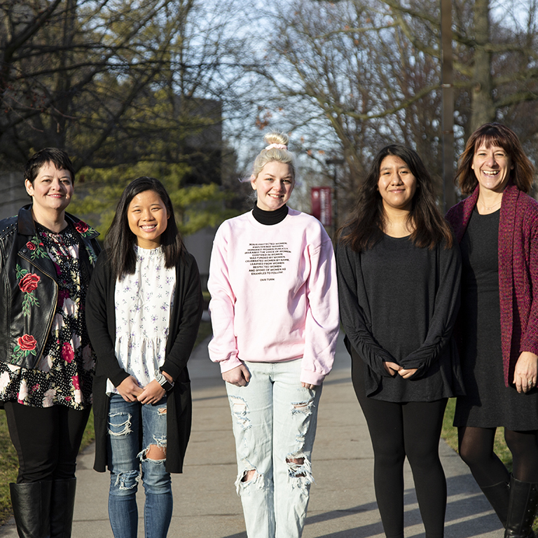 Five women stand in a row