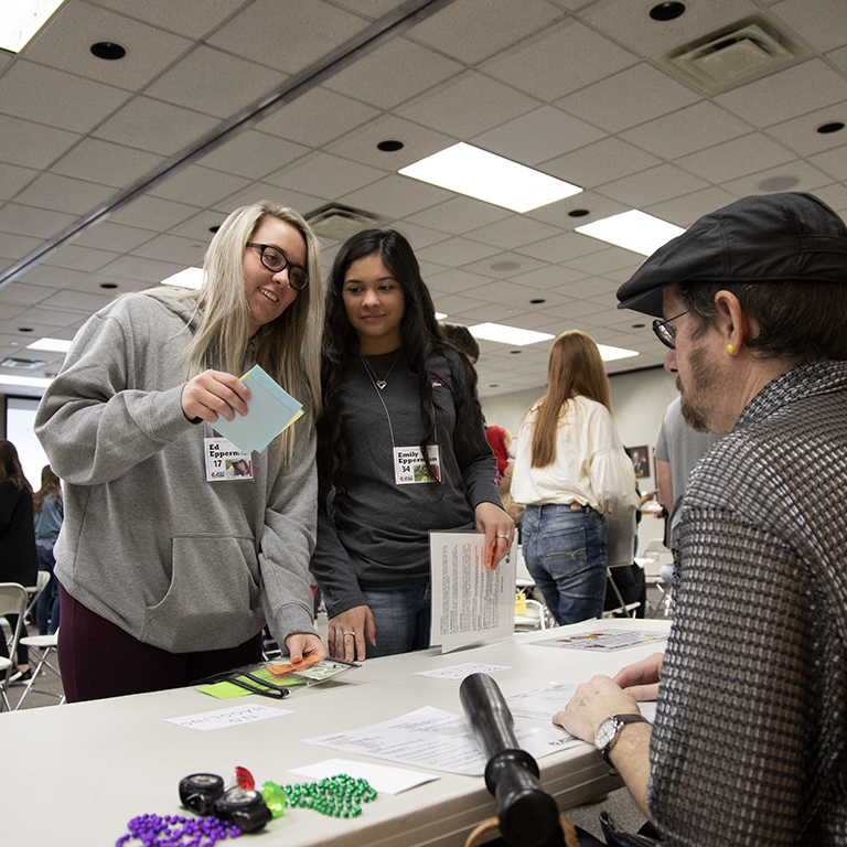 Two women use coupons at a table