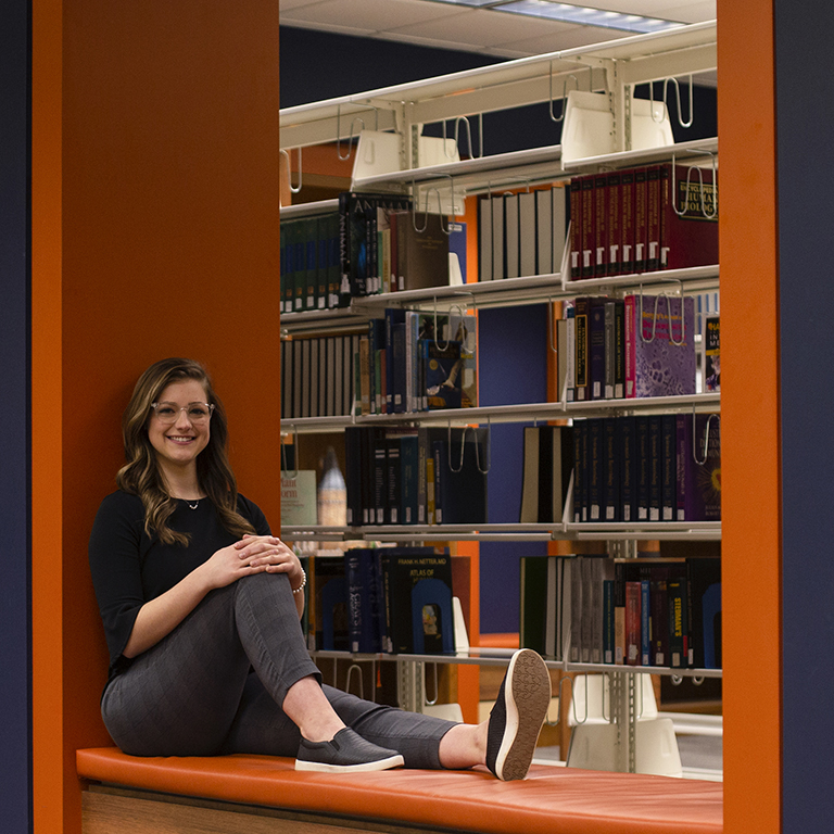 A woman poses in a library