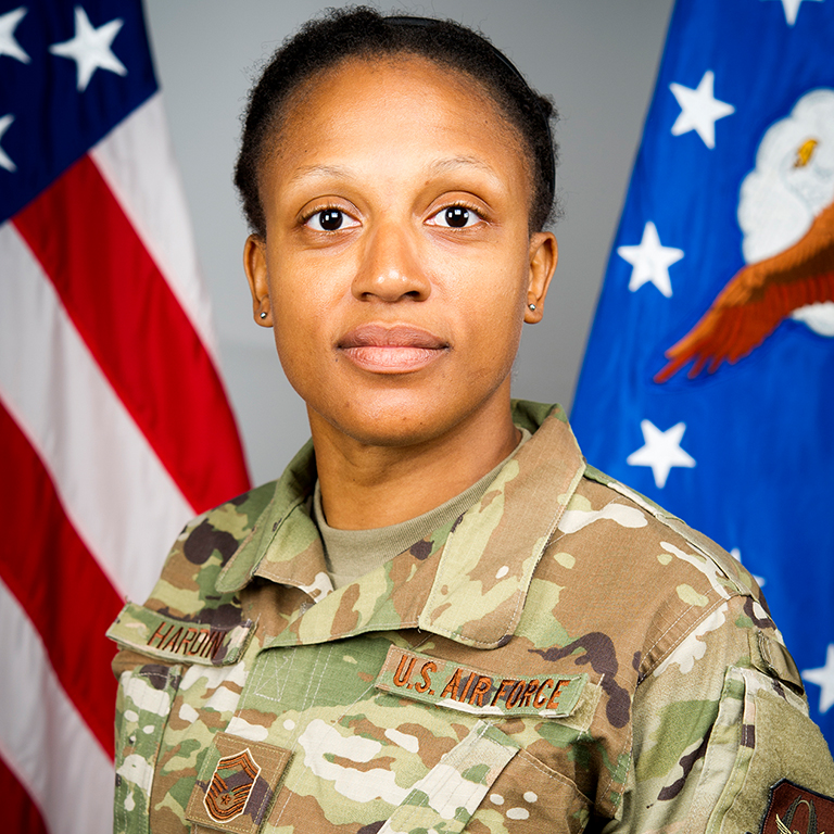 A woman in camouflage poses for a picture