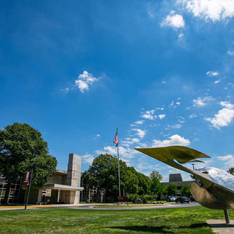 A silver sculpture in front of a limestone building