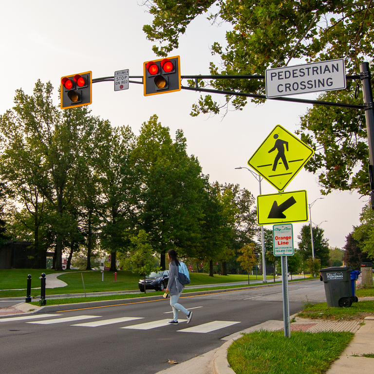 A person crosses the street at a crosswalk