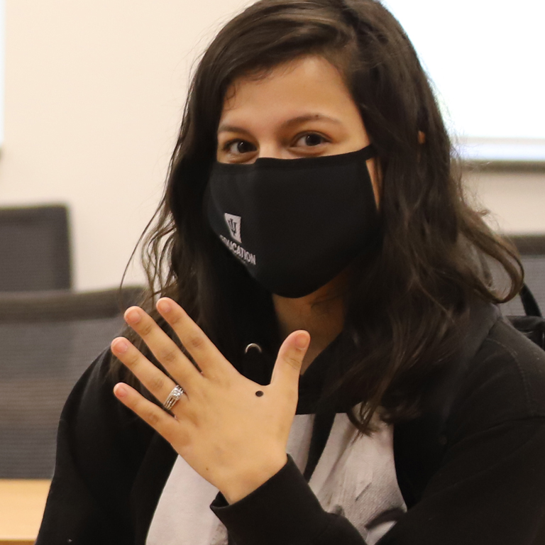 A woman holds up her hand to show a mood dot