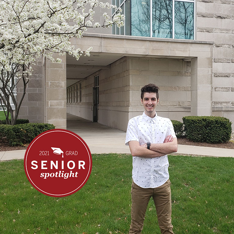 A man stands in front of a building