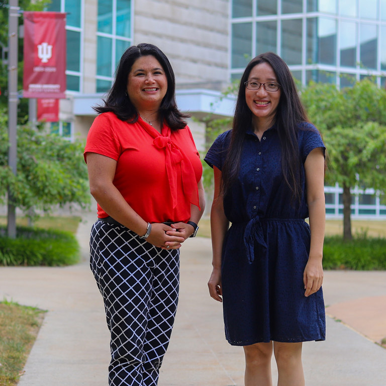two women stand in the quad