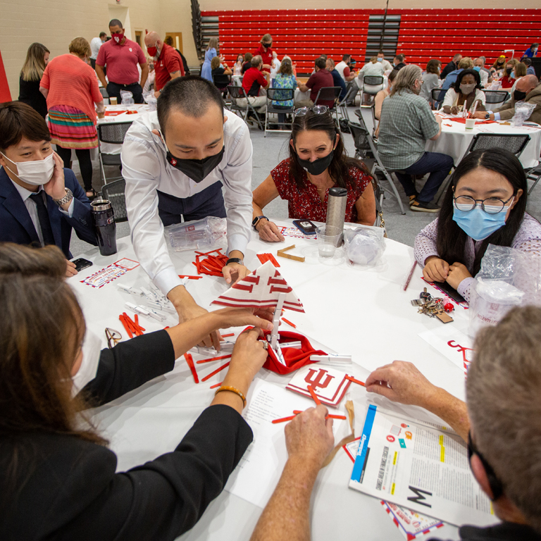 Six masked people solve a puzzle