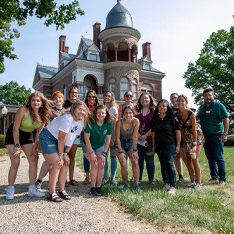 group photo in front of a Queen Anne mansion