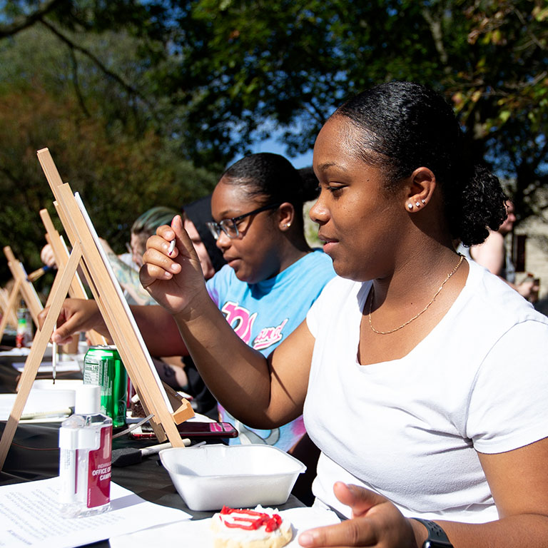 Two women paint on canvases