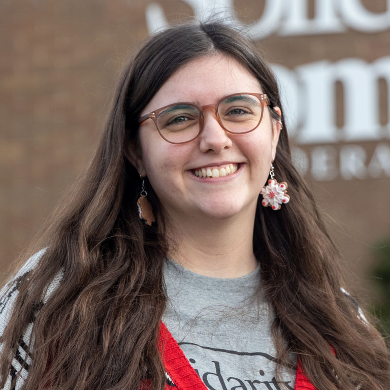 A woman stands in front of a bank
