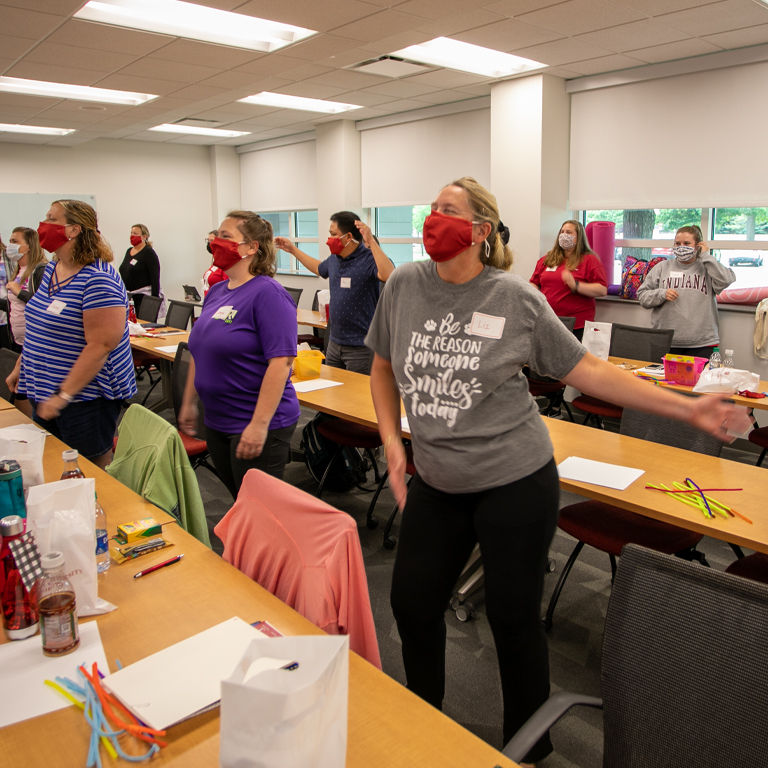A group of women stand in a classroom