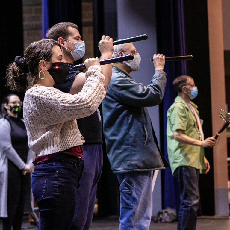 Three people hold up spyglasses