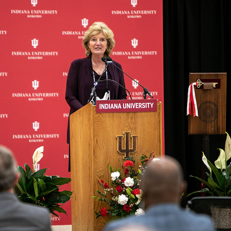 A woman stands at a podium
