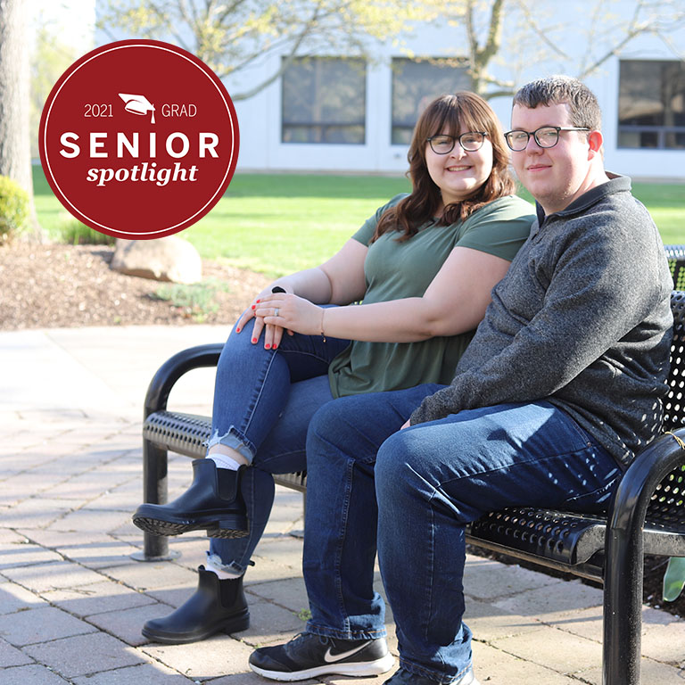 A man and a woman sit on a bench