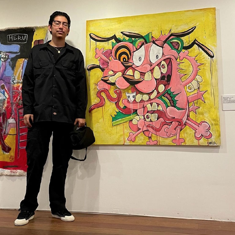 A man stands next to a painting