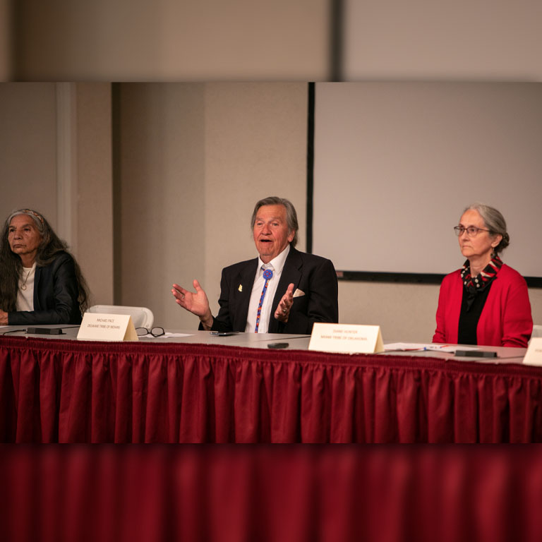Three people sit at a desk