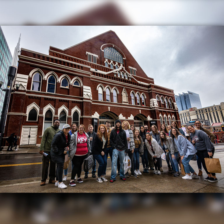 A group of people poses in front of a historic building