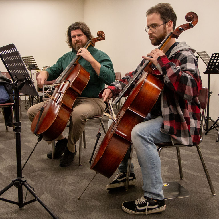 Two men play cellos