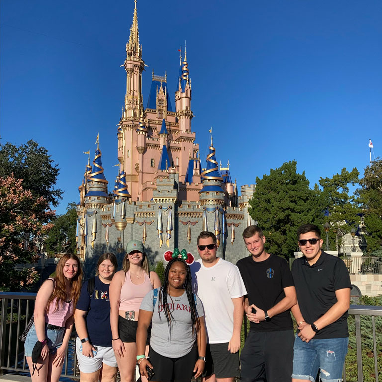 Seven people stand in front of Cinderella Castle at Disney World