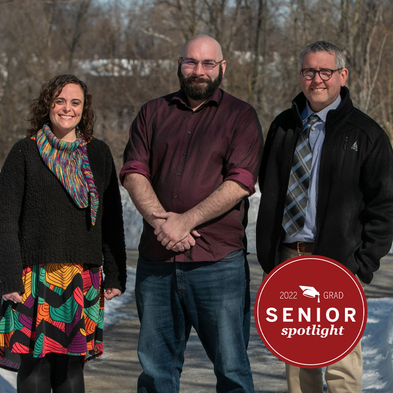 One woman and two men pose for a picture