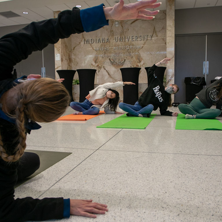 Three people do yoga