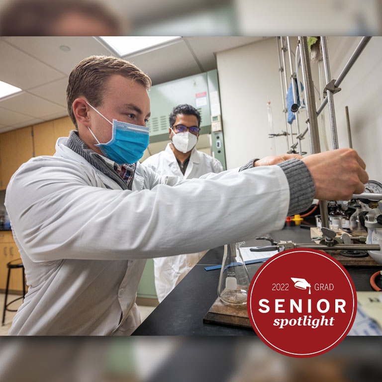 Two men in white lab coats work in a lab