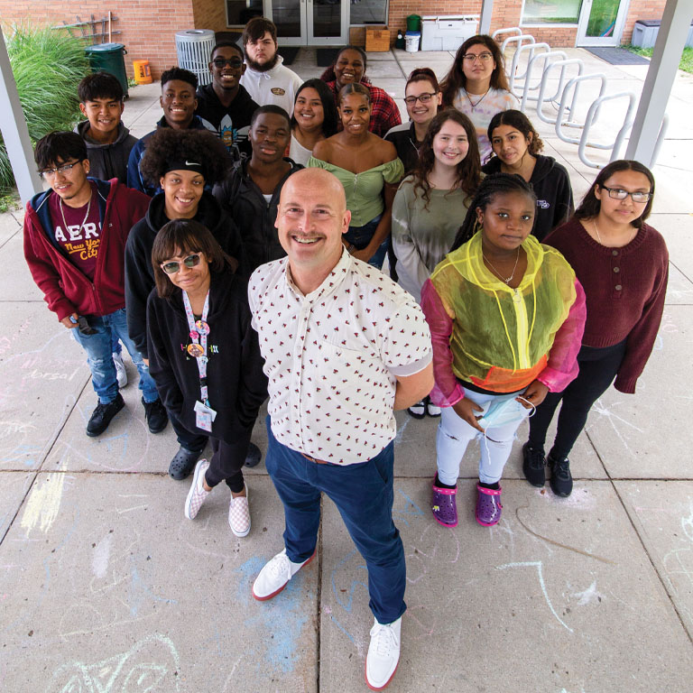 A man poses in front of a group of students