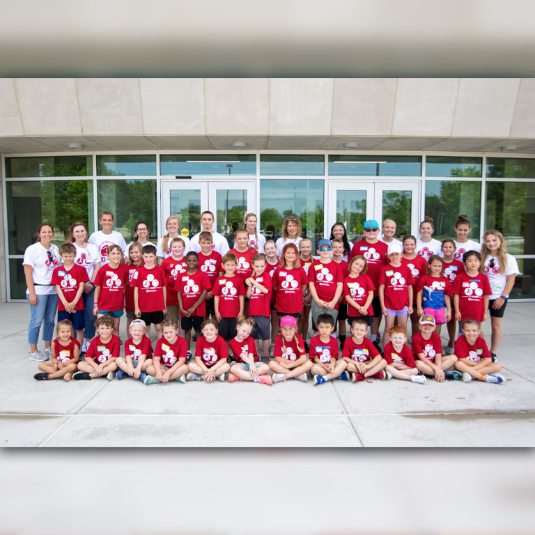 Students and children pose for a group picture.