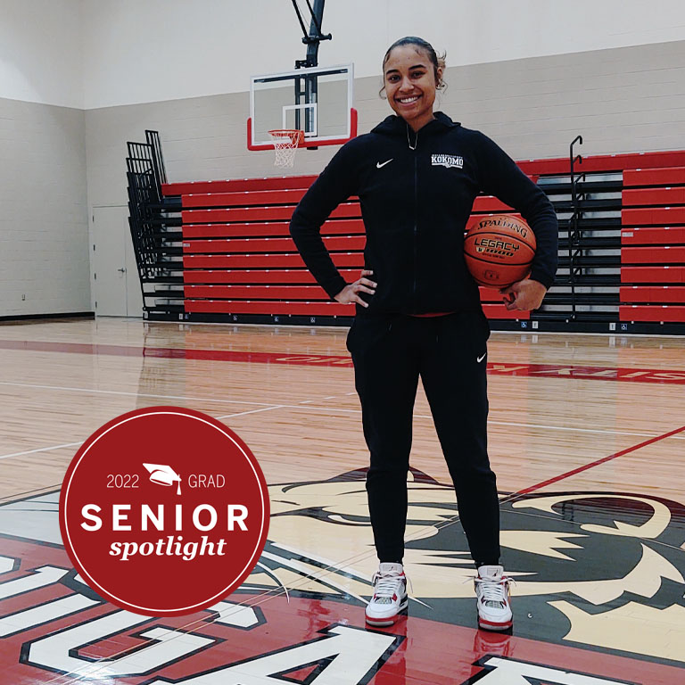 A woman holds a basketball on a court