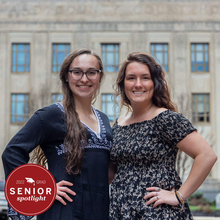 Two women stand in front of a courthouse