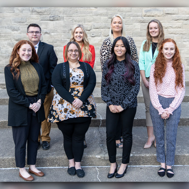 Eight people stand in two lines