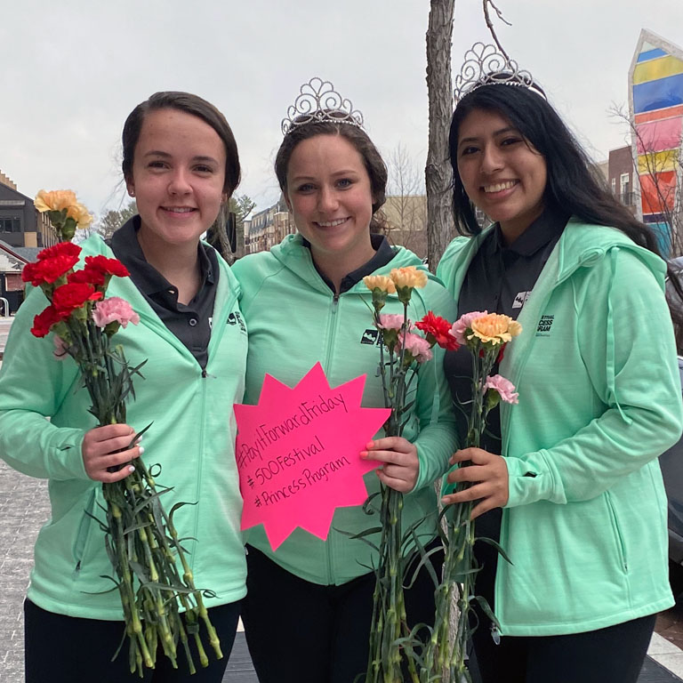 Three women in tiaras pose for pictures