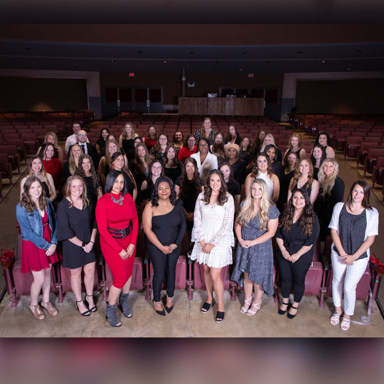 group of nursing students standing in auditorium