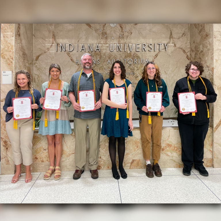 six students wearing honor cords and honor society certificate