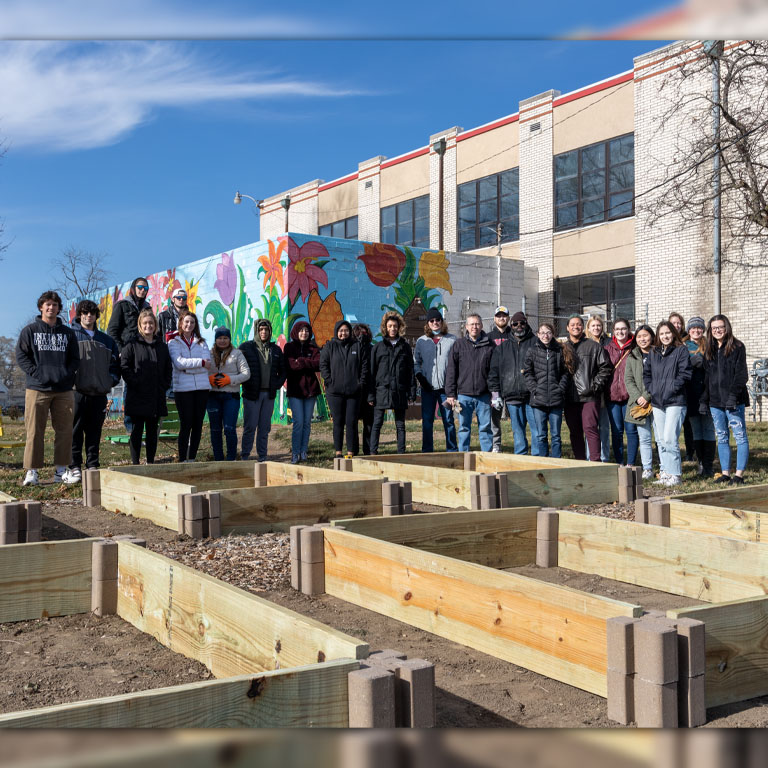 A group of people pose for a picture in a garden