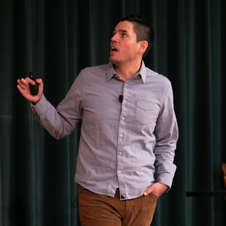 A man speaks on a stage.
