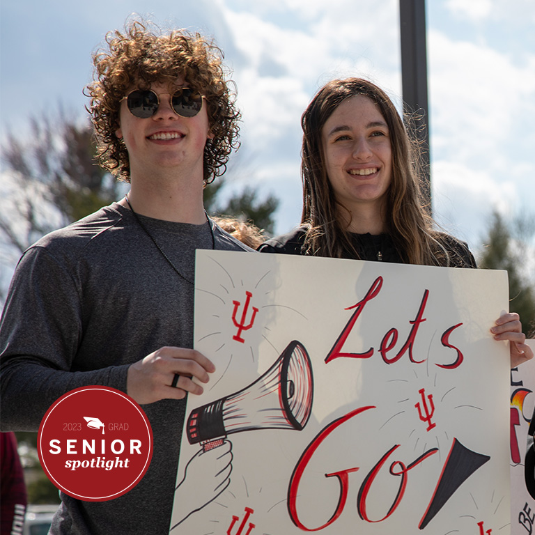 A man and a woman hold a sign.